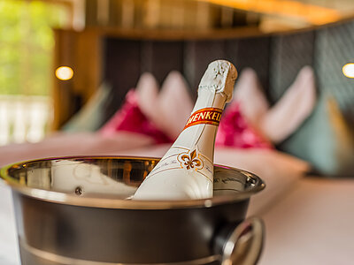 A chilled bottle of sparkling wine in the cosy suite with a hot tub at Hotel Winzer