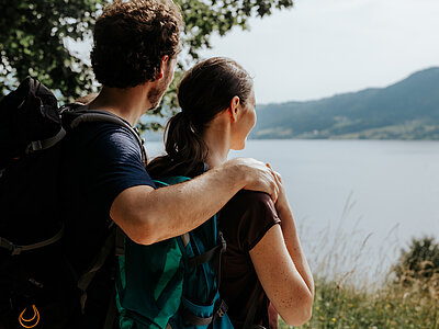 A couple enjoy the view of Lake Attersee whilst hiking
