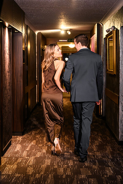 A couple walks down the corridor at the Hotel Winzer