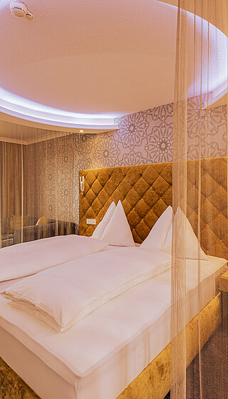 Doppelzimmer Emotion mit gemütlichem Bett im Romantik-Wellnesshotel Winzer