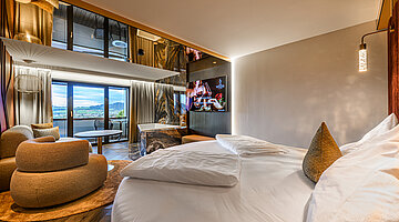 Schlafbereich der Juniorsuite Kuscheltraum Schlafbereich der Juniorsuite Kuscheltraum im Hotel Winzer mit Doppelbett, gemütlicher Sitzecke, Badewanne und Balkon mit Ausblick