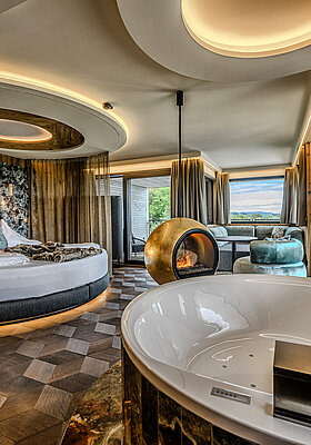 Hideaway Suite mit Whirlpool und Kamin Hideaway Suite im Hotel Winzer mit privatem Whirlpool, rundem Doppelbett, freistehendem Kamin und großzügigem Wohnbereich für zwei