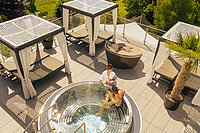 A couple are enjoying the hot tub on the sun deck at the Hotel Winzer