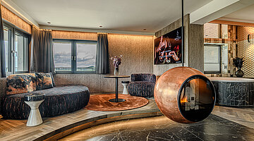 Wohnbereich mit Designkamin Wohnbereich der Wolke 7 im Hotel Winzer mit gemütlicher Sitzecke, außergewöhnlichem Designkamin und privatem Whirlpool