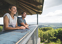 Paar genießt die Aussicht von einem Aussichtsturm in der Region Attersee-Attergau