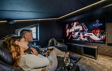Private Cinema der Private Cinema Suite im Hotel Winzer mit großem Bildschirm und bequemen Kinosesseln für entspannte Filmabende zu zweit