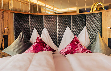 Gemütliches Bett mit Kissen in der Kuschelsuite im Hotel Winzer
