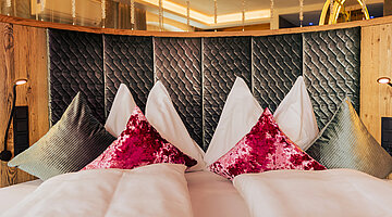 A cosy bed with pillows in the Cosy Suite at Hotel Winzer