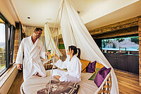 A couple relaxing in floating cosy nests at the Hotel Winze