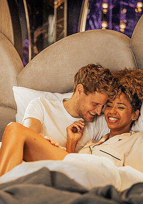 Pärchen entspannt im Bett im Doppelzimmer Spa Deluxe im Hotel Winzer