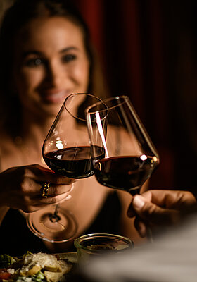 A woman with a glass of wine at the food-sharing table at the Adults Only Hotel Winzer