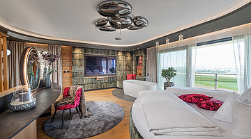 Schlafzimmer mit freistehender Badewanne in der Private Spa Villa im Hotel Winzer