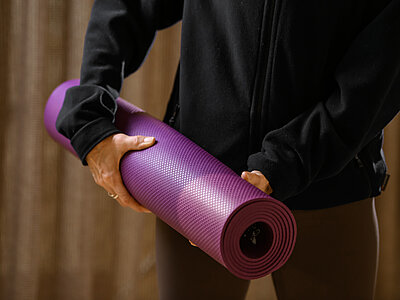 A person with a yoga mat in the wellness area of the Hotel Winzer