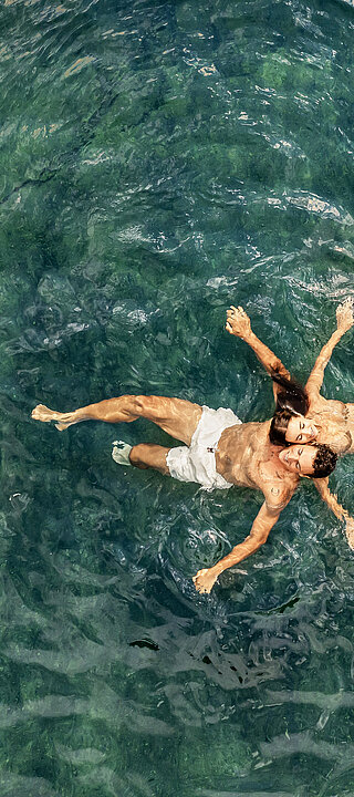 Paar im Wasser des Naturpools im Wellnesshotel Winzer